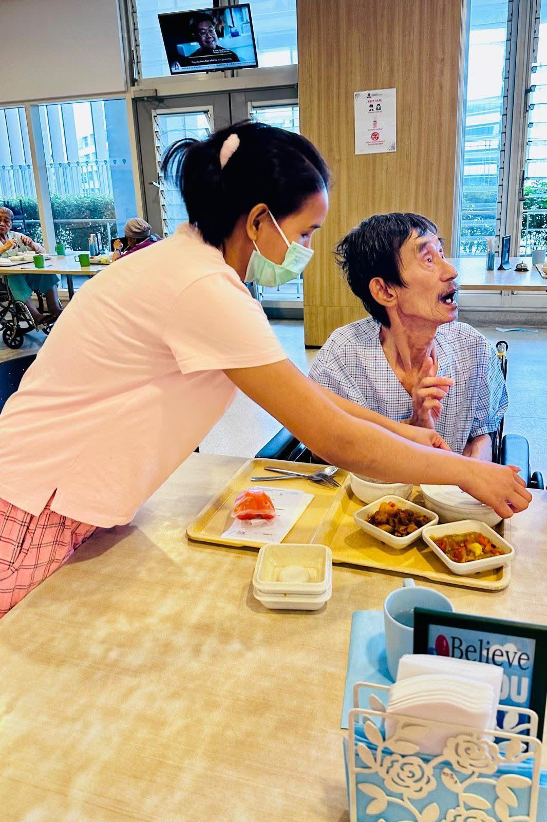 Caregiver assisting elderly patient with walker in hospital